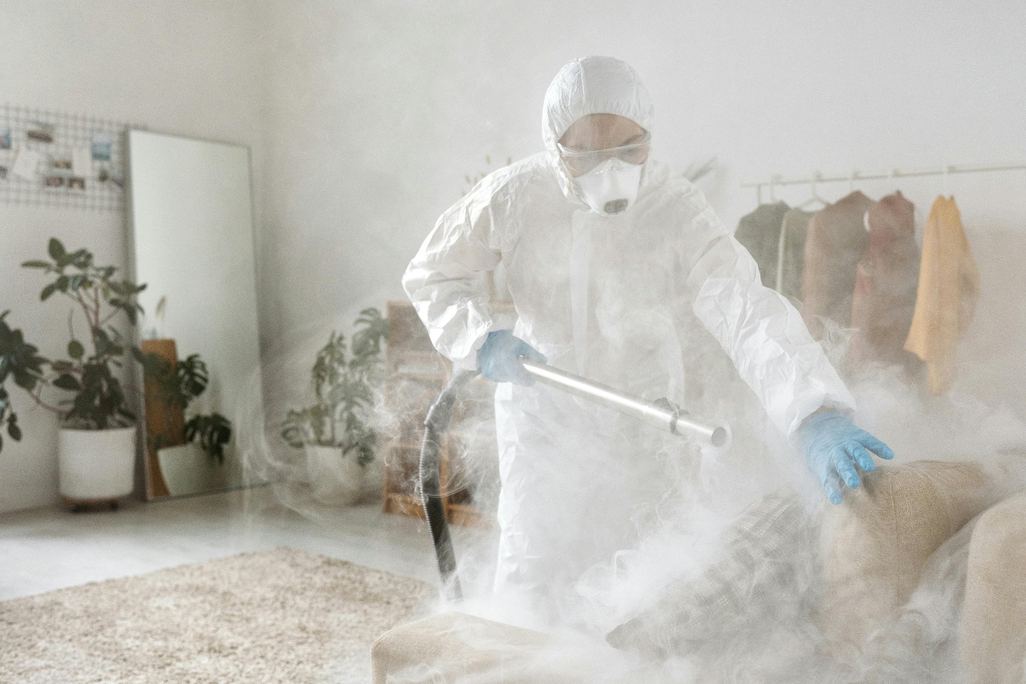 A man in a white hazmat suit fumigates a property